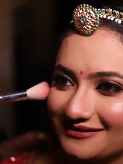 Applying blush to bring a natural, healthy flush to the bride's cheeks. This close-up shows the technique for blending blush seamlessly for that perfect bridal glow.