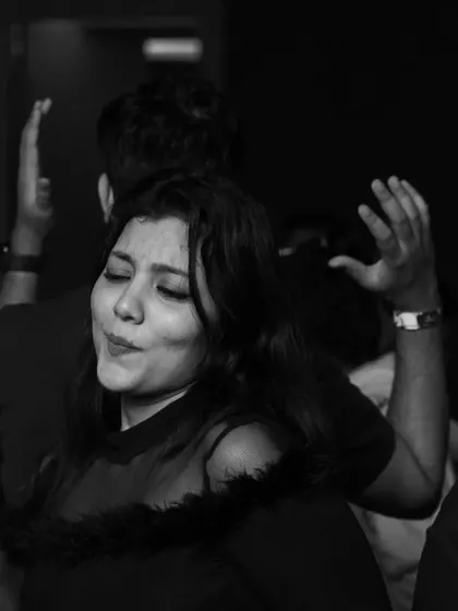 A black and white photo capturing a guest lost in the music, dancing with eyes closed. It's a powerful image of pure enjoyment.