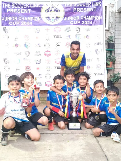 The U9s with their coach and their well-earned trophy after a competitive tournament.