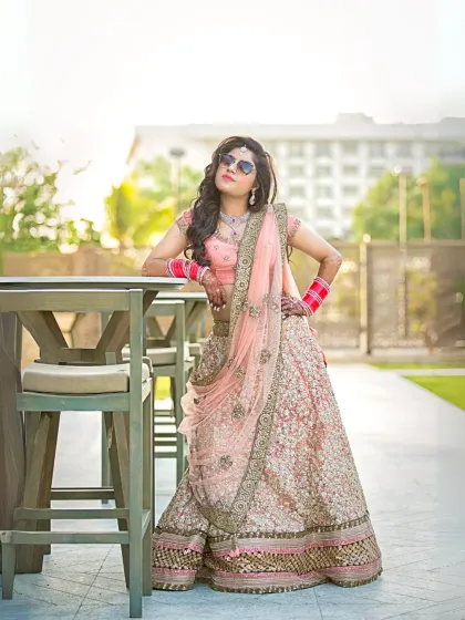 A bride strikes a confident pose with her sunglasses on, leaning against a table. This portrait perfectly captures a modern bride's fun and stylish personality.