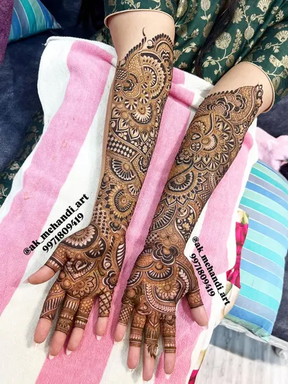 A classic example of full coverage bridal henna. Notice how the patterns on both hands are complementary yet unique, creating a harmonious and visually interesting set.
