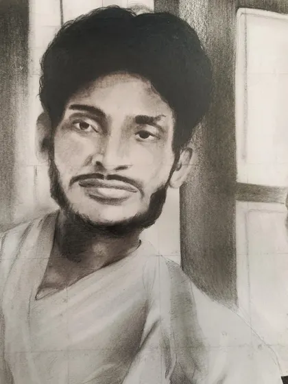 A close-up of the finished charcoal sketch, showing the shading and detail used to bring an old photograph of a young man back to life.