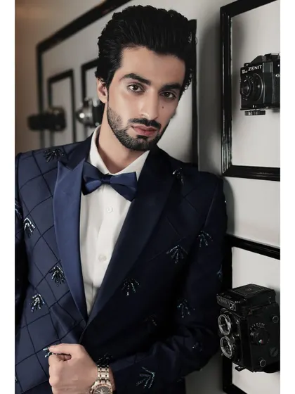 A closer look at our navy embroidered tuxedo. The satin lapel and intricate beadwork on the jacket create a look of refined elegance for any formal occasion.