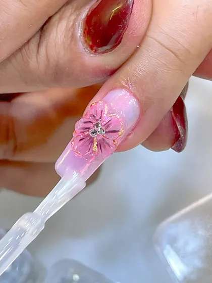 A close-up of a 3D flower being created during a seminar, demonstrating the delicate application of a top coat.