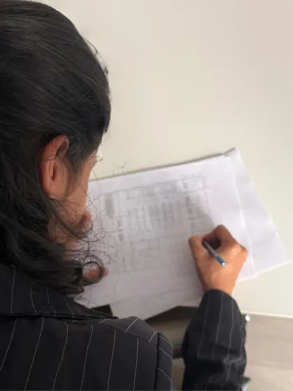 An architect carefully reviewing and marking up a drawing. This attention to detail is a hallmark of our process at every stage.