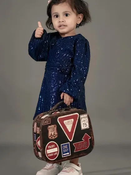 This little traveler is ready to go, with her vintage suitcase and a confident thumbs-up.