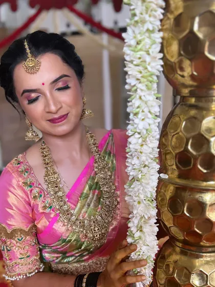 Getting the groom's sister ready for the wedding. This semi-bridal look features a pink-toned eyeshadow to match her beautiful saree, paired with heavy traditional jewellery. The skin is kept looking natural and radiant.