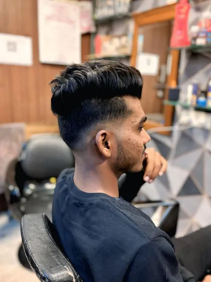 This high fade haircut is styled with the top pushed up and forward for maximum volume. It's a strong and confident look.