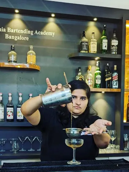Precision is key in professional bartending. Here, a student at our Bangalore academy practices the double-straining technique to ensure a perfectly smooth cocktail, free of ice chips and pulp.