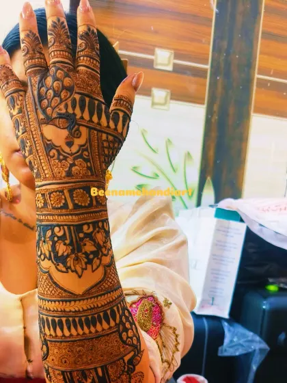 A close-up of a very intricate design. The back of the hand features a beautiful peacock, and the arm is covered in detailed patterns.