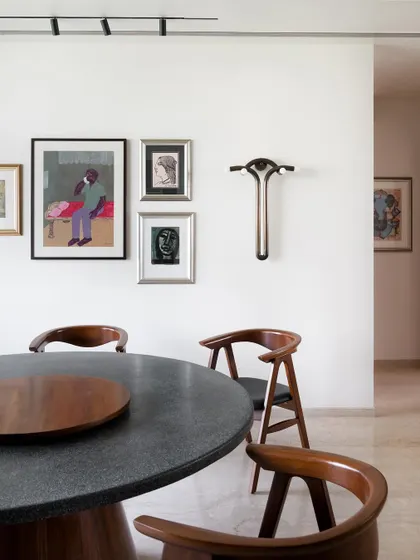 A full view of the round terrazzo dining table and curved teak chairs. I designed this set to encourage conversation, as a round table allows everyone to face each other.