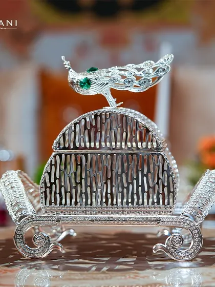 This stunning silverware tissue holder, featuring a beautiful peacock palanquin design, is perfect for elevating any dining setting. It is a small detail that adds a significant touch of regal elegance to your home.