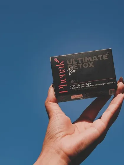 Holding up my Ultimate Detox Bar against the clear blue sky. This soap is formulated for oily skin types to provide a gentle yet deep cleansing experience, helping you achieve a balanced and clear complexion.