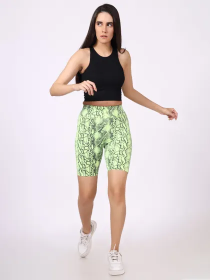 A model in a black crop top and neon snakeskin-print shorts, captured mid-stride to convey movement and energy.