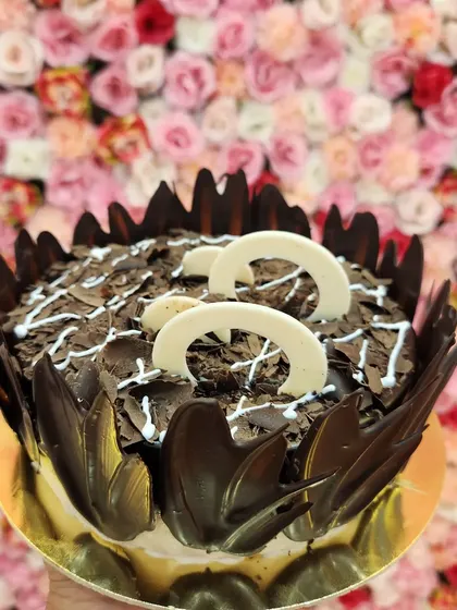 This is my Chocochip Delight cake, loaded with lots of chocolate and love. It's covered in rich chocolate shavings and decorated with white chocolate curls, offering a wonderful mix of textures and chocolatey goodness.