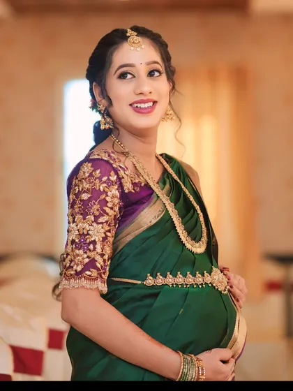 This purple net blouse was a joy to create for my dear client Sowmya's baby shower. The sheer sleeves are adorned with delicate, hand-embroidered floral vines in gold threadwork, creating a look of ethereal elegance for her special day.