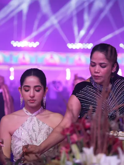 An elegant guest enjoying our offerings. The sophisticated ambiance of the event, with its beautiful lighting, is the perfect backdrop for a gourmet meal.