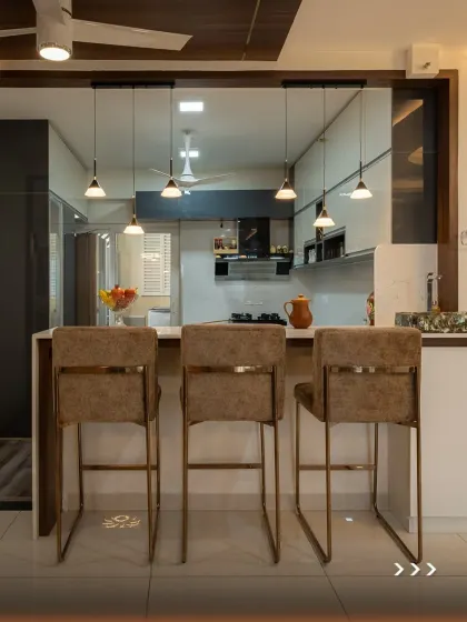 The island in this U-shaped kitchen serves as a breakfast counter, complete with stylish bar stools and elegant pendant lighting. It's a perfect example of how we create multi-functional spaces for modern lifestyles.