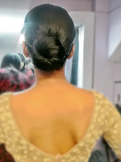 A very simple and clean low twisted bun, secured with bobby pins. This minimalist style is perfect for an understated, elegant look.