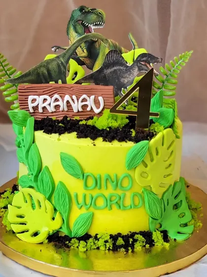 A fun dinosaur-themed cake with minimal fondant. The design uses edible dirt and fondant leaves to create a "Dino World" for the toy toppers.
