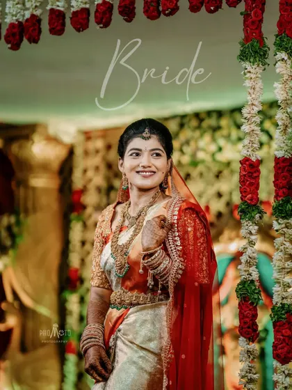 A stunning portrait of the bride against a backdrop of floral garlands, her smile capturing the joy of the day.
