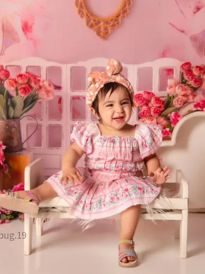 A happy toddler enjoying our pink floral ethnicity-themed setup, perfect for a bright and cheerful portrait.