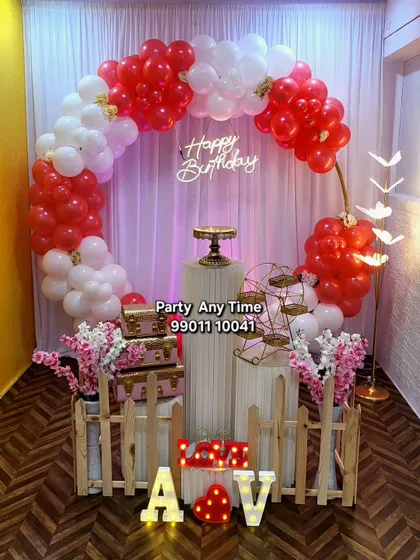 A romantic red and white balloon arch with light-up "LOVE" letters.