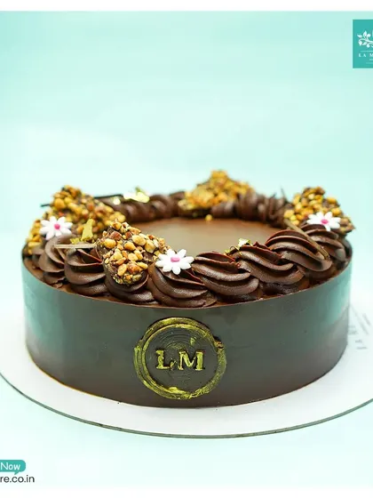 This Chocolate Almond Nougatine cake offers a delightful crunch. The rich chocolate base is topped with piped chocolate cream and clusters of crunchy, caramelized almond nougatine.