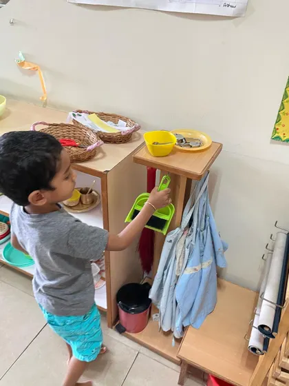 This child is returning a cleaning tool to its designated place. Our prepared environment ensures that everything has a place, which helps children develop a strong sense of order.