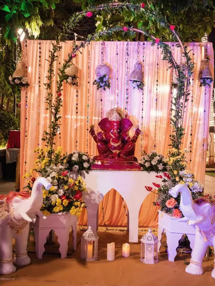 The full view of the Ganpati decor at the entrance, complete with floral arrangements and elephant statues, creating a traditional and welcoming ambiance.