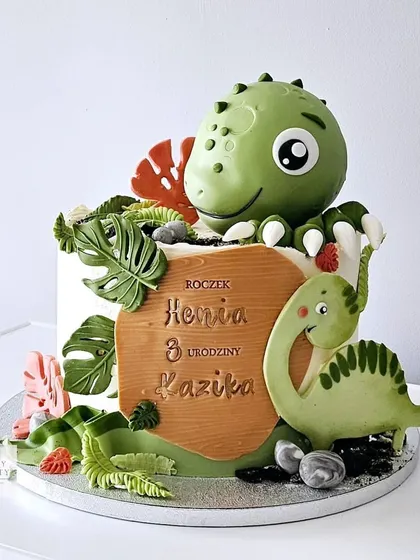 Another angle of the cute green dinosaur cake, showing the personalized wooden name plaque.
