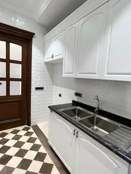 The kitchen at C-257, with its clean white cabinets, black granite countertop, and checkerboard flooring, is a perfect example of our commitment to top-end specifications.