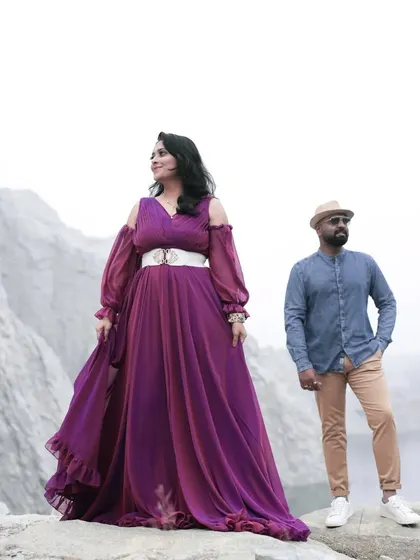 This wine-blue dual-shaded gown is a unique choice for a pre-wedding shoot. The color shifts beautifully in the light, and it pairs wonderfully with a casual denim shirt for a relaxed yet stylish couple's look.
