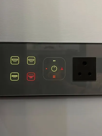 A smart panel with integrated socket, perfect for bedside tables or kitchen counters. It combines control for lights and AC with a practical power outlet.