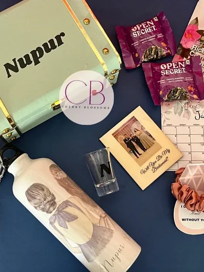 A complete bridesmaid hamper, perfect for asking your best friends to stand by your side. This personalised trunk box includes a custom sipper, polaroid magnet, shot glass, snacks, and self-care items.