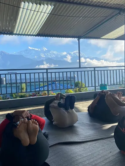 Students in a gentle hip-opening pose during our morning practice, with the stunning Annapurna range in the background.