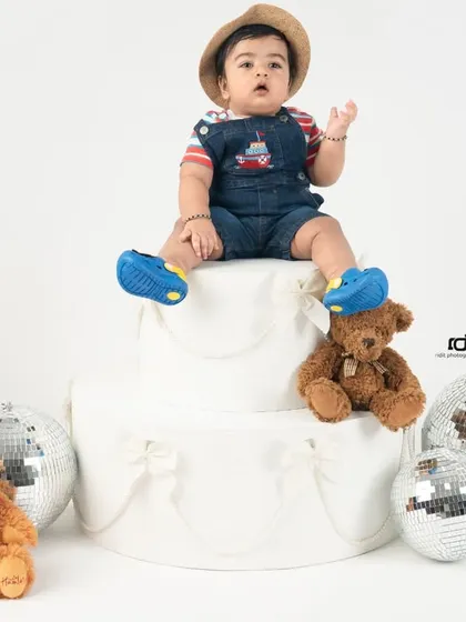 Sitting on top of the world, or at least on top of the cake. This is such a fun and confident pose for a one-year-old.