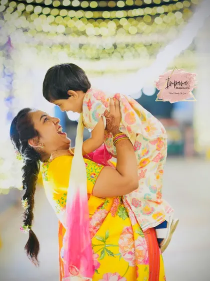 A joyful moment between a mother and her child. Her reception makeup is bright and festive, matching the happy atmosphere.