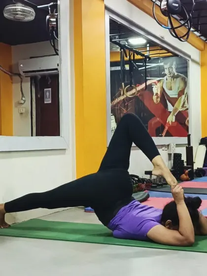 This advanced supine stretch, Eka Pada Supta Virasana variation, requires deep hip and quadriceps flexibility.