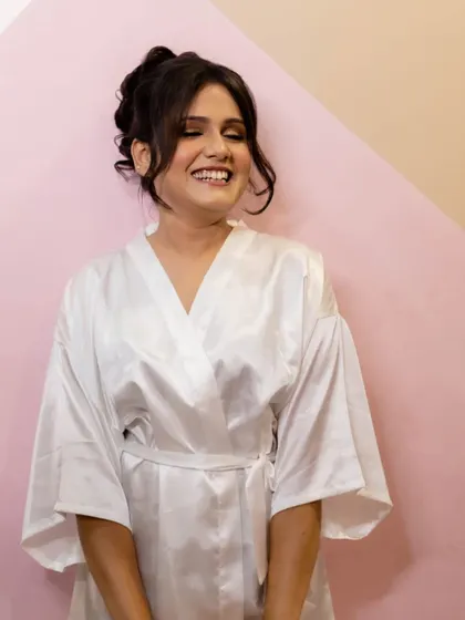 A happy, candid shot of the bride in her getting-ready robe. Her smile shows the excitement and anticipation of the day.