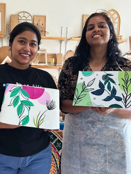 Two participants showing off the beautiful lampshades they painted.
