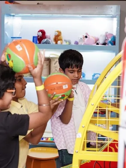 Kids playing a basketball arcade game, another fun option in our entertainment zone.