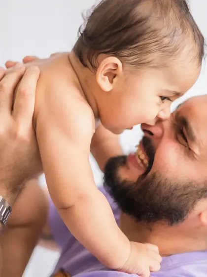 A close up of that playful "daddy cool" moment. This image captures the pure happiness and affection in their interaction, making it a powerful visual for any brand focused on family and care.
