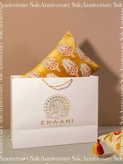 My signature gift bag, featuring our peacock logo, is a promise of the elegance that lies within. Here, it holds a beautiful cushion from one of my collections, ready to be gifted.