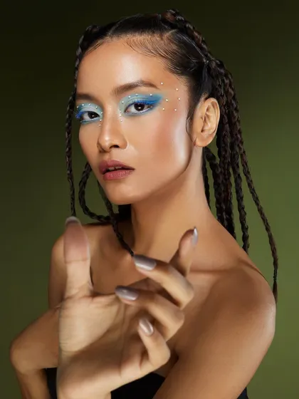 A dynamic shot that highlights the intricate details of the icy blue makeup and the model's confident pose.