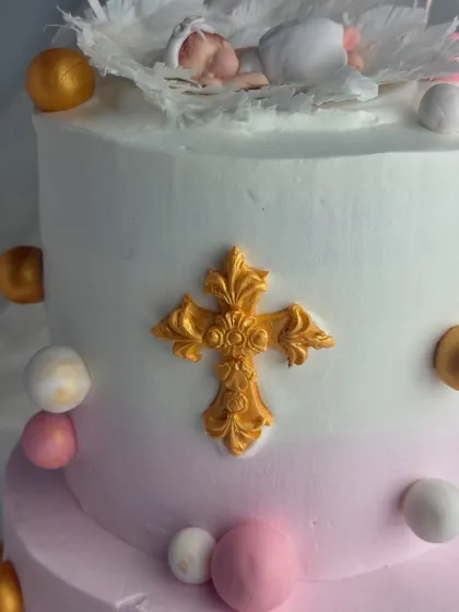A detailed shot of the golden cross accent on the baptism cake.