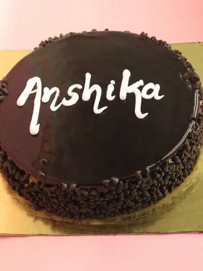 A classic eggless Dutch Truffle cake, personalized for a birthday. The sides are coated in chocolate chips, and the top has a flawless mirror glaze.