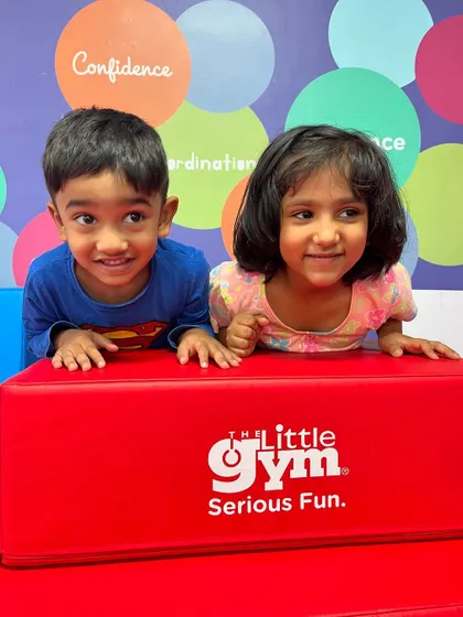 Two friends peeking over a block, ready for their next adventure. Our gym is a place where social skills blossom, and children learn to play and explore together.