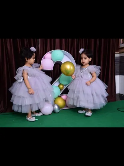 These adorable twins are celebrating their second birthday in matching lavender layered gowns I designed for them.