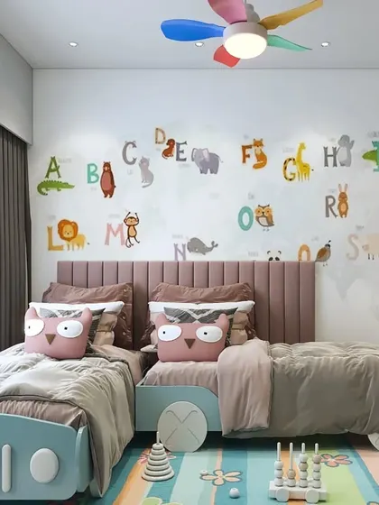 A shared room for younger children with two car-shaped beds and a fun, educational alphabet wall decal. The design is playful and colorful.